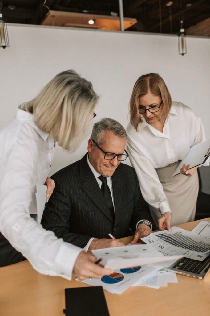 Trois collaborateurs et dirigeants de TPE analysent des documents autour d'une table